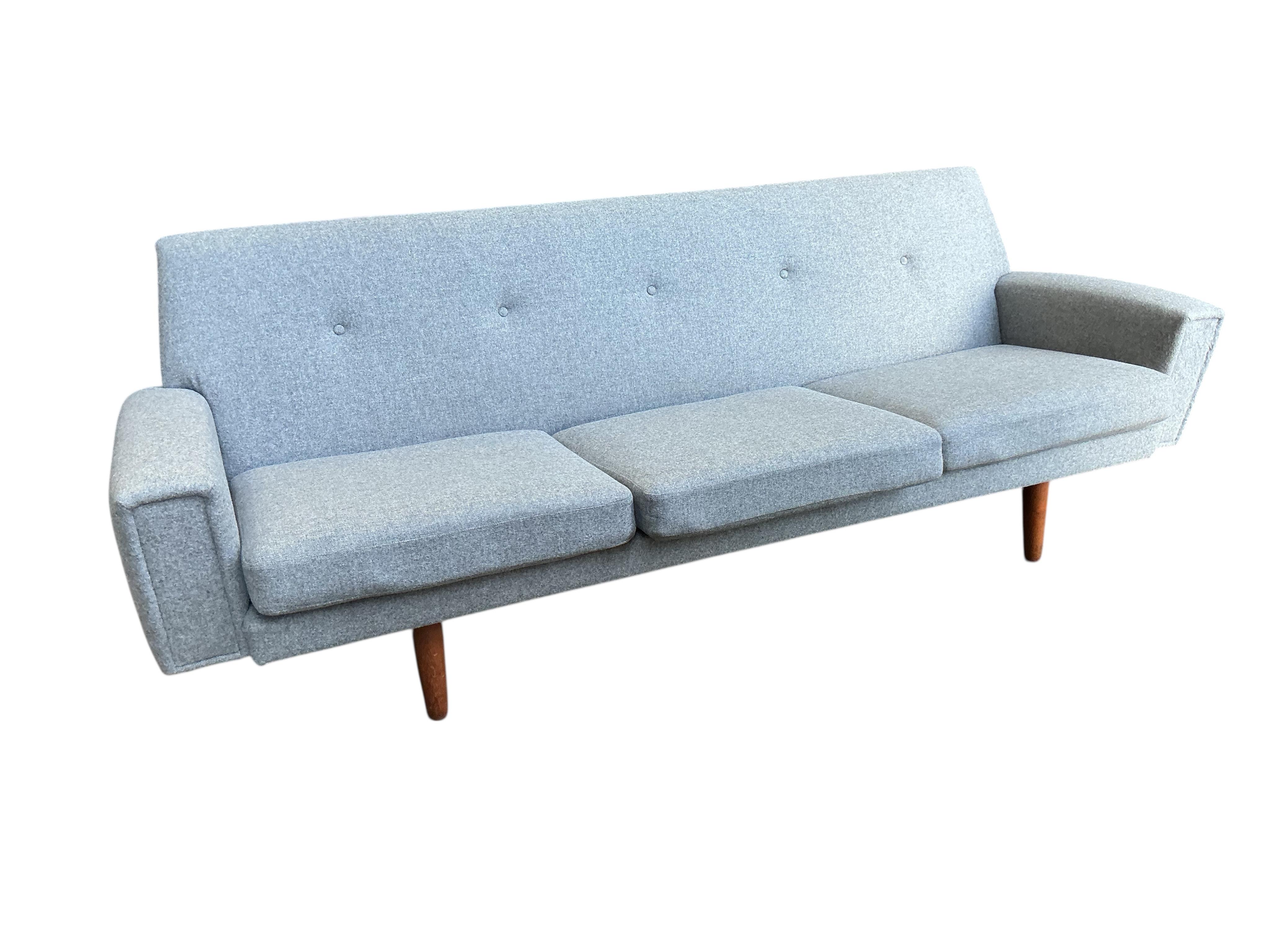 In the manner of Georg Thams, a Danish style mid century design three seater settee upholstered in grey wool fabric, width 214cm, depth 68cm, height 73cm